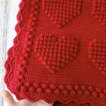 Hand-knitted baby blanket with heart pattern, red and embossed 💕