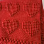 Hand-knitted baby blanket with heart pattern, red and embossed 💕