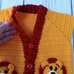Hand-knitted, lion-themed, yellow and red baby cardigan