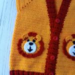 Hand-knitted, lion-themed, yellow and red baby cardigan